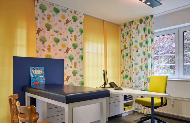 Kinderärzte Ziegler Behandlungszimmer rechts Kinderärzte Ziegler Behandlungszimmer Untersuchungsbank mit Kinderbuch