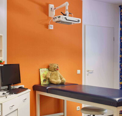 Kinderärzte Ziegler Behandlungszimmer Untersuchungsbank mit Teddy